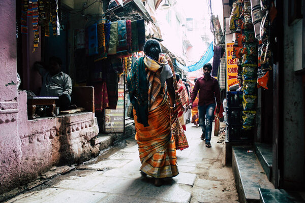 Varanasi India November 19, 2018 View of unknown Indian people walking in the narrow street in the old district of Varanasi in the afternoon