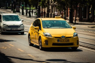 Budapeşte Macaristan 11 Temmuz 2020 Budapeşte 'nin başkenti ve Macaristan' ın en kalabalık şehri olan Budapeşte sokaklarında seyahat eden yolcular için geleneksel sarı bir Macar taksisine bakınız.