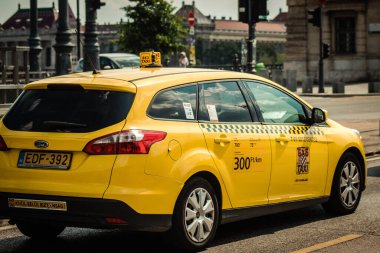 Budapeşte Macaristan 11 Temmuz 2020 Budapeşte 'nin başkenti ve Macaristan' ın en kalabalık şehri olan Budapeşte sokaklarında seyahat eden yolcular için geleneksel sarı bir Macar taksisine bakınız.