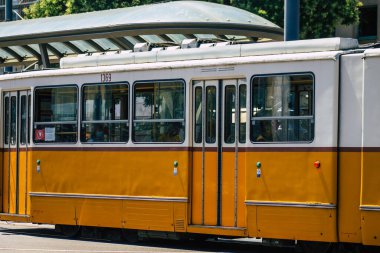 Budapeşte Macaristan 12 Temmuz 2020. Macaristan 'ın başkenti Budapeşte' nin sokaklarında ve toplu taşıma sisteminin bir bölümünde seyahat eden yolcular için geleneksel bir Macar elektrikli tramvayı görülüyor.