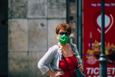 Budapeşte Macaristan 20 Temmuz 2020 'de Macaristan' ın başkenti Budapeşte 'nin eski sokaklarında yürüyen koronavirüsten korunmak için yüzü maskeli kimliği belirsiz yayalara bakıldı.