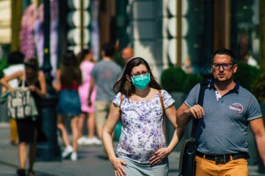 Budapeşte Macaristan 20 Temmuz 2020 'de Macaristan' ın başkenti Budapeşte 'nin eski sokaklarında yürüyen koronavirüsten korunmak için yüzü maskeli kimliği belirsiz yayalara bakıldı.