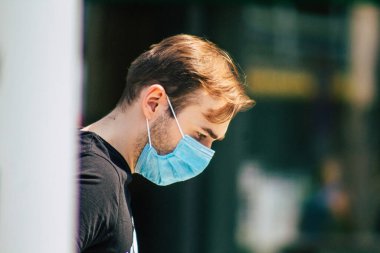 Budapeşte Macaristan 22 Temmuz 2020 Macaristan 'ın başkenti Budapeşte' nin eski sokaklarında yürüyen koronavirüsten korunmak için yüzü maskeli, kimliği belirsiz yayalara bakınız.