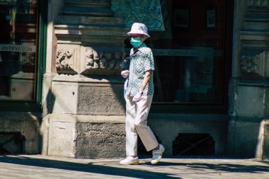 Budapeşte Macaristan 22 Temmuz 2020 Macaristan 'ın başkenti Budapeşte' nin eski sokaklarında yürüyen koronavirüsten korunmak için yüzü maskeli, kimliği belirsiz yayalara bakınız.