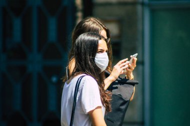 Budapeşte Macaristan 22 Temmuz 2020 Macaristan 'ın başkenti Budapeşte' nin eski sokaklarında yürüyen koronavirüsten korunmak için yüzü maskeli, kimliği belirsiz yayalara bakınız.