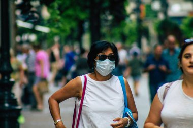 Budapeşte Macaristan 22 Temmuz 2020 Macaristan 'ın başkenti Budapeşte' nin eski sokaklarında yürüyen koronavirüsten korunmak için yüzü maskeli, kimliği belirsiz yayalara bakınız.