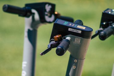 Lizbon Portekiz 25 Temmuz 2020 'de Lizbon sokaklarında park etmiş küçük bir iç yanmalı motor ve merkezde büyük bir güverte ile çalışan elektrikli scooter görüntüsü.