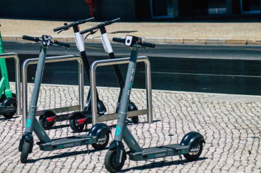 Lizbon Portekiz 25 Temmuz 2020 'de Lizbon sokaklarında park etmiş küçük bir iç yanmalı motor ve merkezde büyük bir güverte ile çalışan elektrikli scooter görüntüsü.