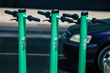 Lizbon Portekiz 25 Temmuz 2020 'de Lizbon sokaklarında park etmiş küçük bir iç yanmalı motor ve merkezde büyük bir güverte ile çalışan elektrikli scooter görüntüsü.