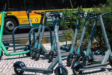 Lizbon Portekiz 25 Temmuz 2020 'de Lizbon sokaklarında park etmiş küçük bir iç yanmalı motor ve merkezde büyük bir güverte ile çalışan elektrikli scooter görüntüsü.
