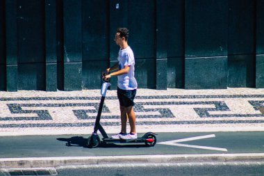 Lizbon Portekiz 25 Temmuz 2020 Lizbon sokaklarında elektrikli scooterla dolaşan, küçük bir iç yanmalı motorla çalışan ve merkezde bir güverte bulunan kimliği belirsiz insanların görüntüsü.