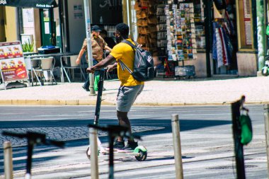 Lizbon Portekiz 28 Temmuz 2020 Lizbon sokaklarında elektrikli scooterla gezen kimliği belirsiz insanların görüntüsü, küçük bir iç yanmalı motorlar ve merkezde bir güverte ile çalışıyor.