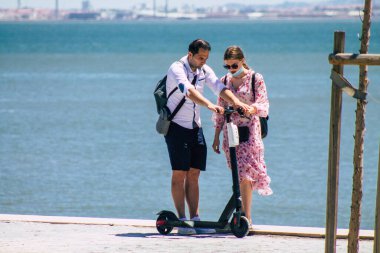 Lizbon Portekiz 28 Temmuz 2020 Lizbon sokaklarında elektrikli scooterla gezen kimliği belirsiz insanların görüntüsü, küçük bir iç yanmalı motorlar ve merkezde bir güverte ile çalışıyor.