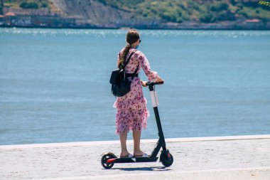 Lizbon Portekiz 28 Temmuz 2020 Lizbon sokaklarında elektrikli scooterla gezen kimliği belirsiz insanların görüntüsü, küçük bir iç yanmalı motorlar ve merkezde bir güverte ile çalışıyor.