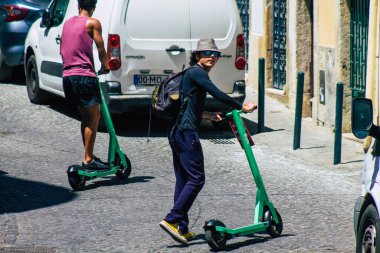 Lizbon Portekiz 01 Ağustos 2020 Lizbon sokaklarında elektrikli scooterla dolaşan kimliği belirsiz insanların görüntüsü, küçük bir iç yanmalı motorlar ve merkezde bir güverte ile çalışıyor.