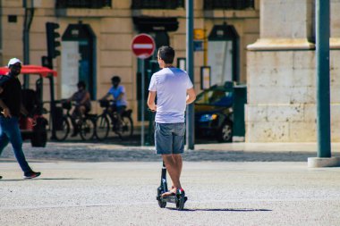 Lizbon Portekiz 01 Ağustos 2020 Lizbon sokaklarında elektrikli scooterla dolaşan kimliği belirsiz insanların görüntüsü, küçük bir iç yanmalı motorlar ve merkezde bir güverte ile çalışıyor.