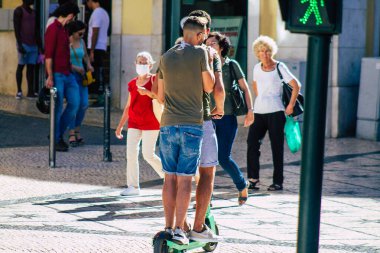 Lizbon Portekiz 01 Ağustos 2020 Lizbon sokaklarında elektrikli scooterla dolaşan kimliği belirsiz insanların görüntüsü, küçük bir iç yanmalı motorlar ve merkezde bir güverte ile çalışıyor.