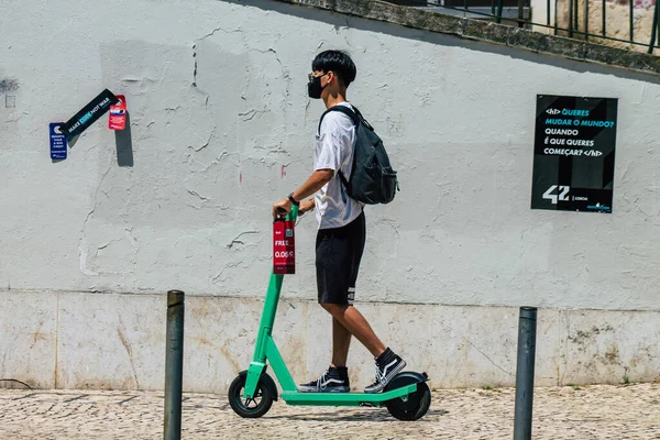 Lizbon 4 Ağustos 2020 'de Lizbon sokaklarında elektrikli scooterla dolaşan kimliği belirsiz insanların küçük bir iç yanmalı motorlar ve merkezde bir güverte ile çalışmalarını izledik.