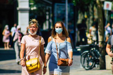 Reims, Fransa 6 Ağustos 2020 'de, Fransa' nın Büyük Doğu bölgesindeki bir şehir olan Reims sokaklarında yürüyen koronavirüsten kendilerini korumak için maske takan kimliği belirsiz yayalara bakmaktadır.