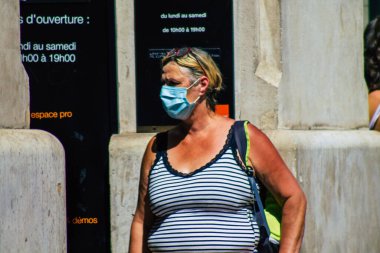 Reims, Fransa 6 Ağustos 2020 'de, Fransa' nın Büyük Doğu bölgesindeki bir şehir olan Reims sokaklarında yürüyen koronavirüsten kendilerini korumak için maske takan kimliği belirsiz yayalara bakmaktadır.