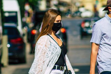 Reims, Fransa 6 Ağustos 2020 'de, Fransa' nın Büyük Doğu bölgesindeki bir şehir olan Reims sokaklarında yürüyen koronavirüsten kendilerini korumak için maske takan kimliği belirsiz yayalara bakmaktadır.