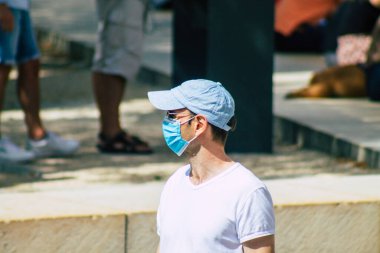 Fransa 'yı 15 Ağustos 2020' de, Fransa 'nın Grand Est bölgesindeki bir şehir olan Reims sokaklarında yürüyen koronavirüsten kendilerini korumak için maske takan kimliği belirsiz yayalara bakıyor.
