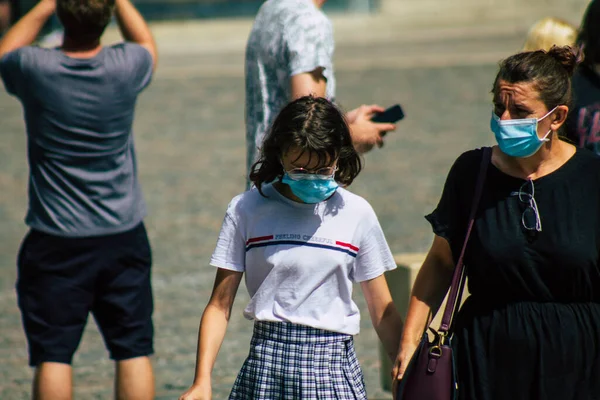 Fransa 'yı 15 Ağustos 2020' de, Fransa 'nın Grand Est bölgesindeki bir şehir olan Reims sokaklarında yürüyen koronavirüsten kendilerini korumak için maske takan kimliği belirsiz yayalara bakıyor.