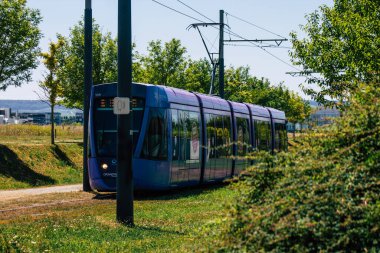 Fransa 'yı 15 Ağustos 2020' de, Fransa 'nın Grand Est bölgesindeki bir şehir olan Reims toplu taşıma sisteminin bir parçası olan caddelerden geçen yolculara yönelik modern bir elektrikli tramvaya bakıyor.