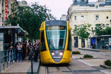 Fransa 'yı 15 Ağustos 2020' de, Fransa 'nın Grand Est bölgesindeki bir şehir olan Reims toplu taşıma sisteminin bir parçası olan caddelerden geçen yolculara yönelik modern bir elektrikli tramvaya bakıyor.