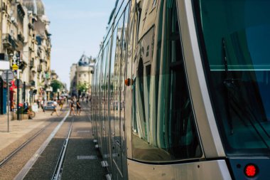 Fransa 'yı 20 Ağustos 2020' de, Fransa 'nın Grand Est bölgesindeki bir şehir olan Reims toplu taşıma sisteminin bir parçası olan caddelerden geçen yolcular için modern bir elektrikli tramvaya bakıyor.