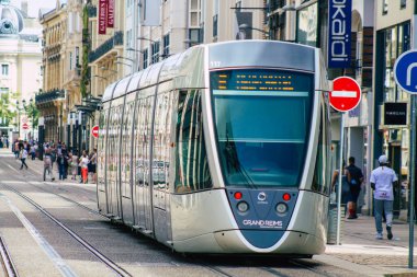 Fransa 'yı 20 Ağustos 2020' de, Fransa 'nın Grand Est bölgesindeki bir şehir olan Reims toplu taşıma sisteminin bir parçası olan caddelerden geçen yolcular için modern bir elektrikli tramvaya bakıyor.