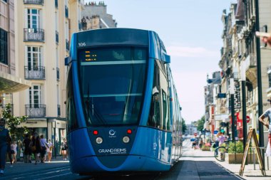 Fransa 'yı 20 Ağustos 2020' de, Fransa 'nın Grand Est bölgesindeki bir şehir olan Reims toplu taşıma sisteminin bir parçası olan caddelerden geçen yolcular için modern bir elektrikli tramvaya bakıyor.