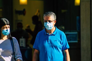 Fransa 4 Eylül 2020 'de, Fransa' nın Büyük Doğu bölgesindeki bir şehir olan Reims sokaklarında yürüyen ve kendilerini koronavirüsten korumak için maske takan kimliği belirsiz yayalara bakmaktadır.