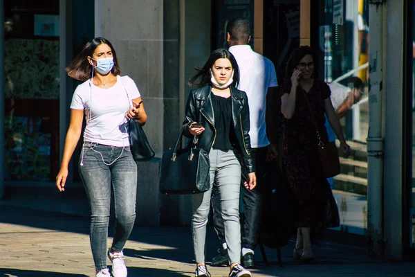 Fransa 4 Eylül 2020 'de, Fransa' nın Büyük Doğu bölgesindeki bir şehir olan Reims sokaklarında yürüyen ve kendilerini koronavirüsten korumak için maske takan kimliği belirsiz yayalara bakmaktadır.