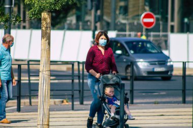 Fransa 'yı 12 Eylül 2020' de, Fransa 'nın Grand Est bölgesindeki bir şehir olan Reims sokaklarında yürüyen koronavirüsten kendilerini korumak için maske takan kimliği belirsiz yayalara bakıyor.