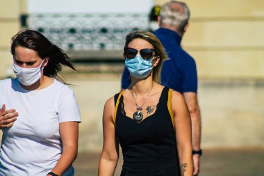 Fransa 'yı 12 Eylül 2020' de, Fransa 'nın Grand Est bölgesindeki bir şehir olan Reims sokaklarında yürüyen koronavirüsten kendilerini korumak için maske takan kimliği belirsiz yayalara bakıyor.