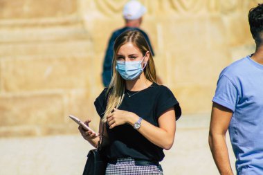 Fransa 'yı 12 Eylül 2020' de, Fransa 'nın Grand Est bölgesindeki bir şehir olan Reims sokaklarında yürüyen koronavirüsten kendilerini korumak için maske takan kimliği belirsiz yayalara bakıyor.