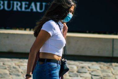 Fransa 'yı 12 Eylül 2020' de, Fransa 'nın Grand Est bölgesindeki bir şehir olan Reims sokaklarında yürüyen koronavirüsten kendilerini korumak için maske takan kimliği belirsiz yayalara bakıyor.