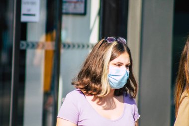 Fransa 'yı 12 Eylül 2020' de, Fransa 'nın Grand Est bölgesindeki bir şehir olan Reims sokaklarında yürüyen koronavirüsten kendilerini korumak için maske takan kimliği belirsiz yayalara bakıyor.