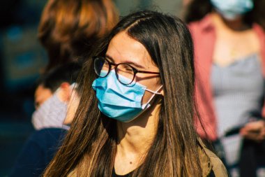 Fransa 'yı 12 Eylül 2020' de, Fransa 'nın Grand Est bölgesindeki bir şehir olan Reims sokaklarında yürüyen koronavirüsten kendilerini korumak için maske takan kimliği belirsiz yayalara bakıyor.