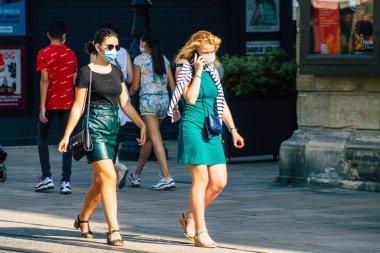 Fransa 'yı 12 Eylül 2020' de, Fransa 'nın Grand Est bölgesindeki bir şehir olan Reims sokaklarında yürüyen koronavirüsten kendilerini korumak için maske takan kimliği belirsiz yayalara bakıyor.