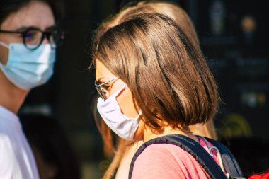 Fransa 'yı 12 Eylül 2020' de, Fransa 'nın Grand Est bölgesindeki bir şehir olan Reims sokaklarında yürüyen koronavirüsten kendilerini korumak için maske takan kimliği belirsiz yayalara bakıyor.