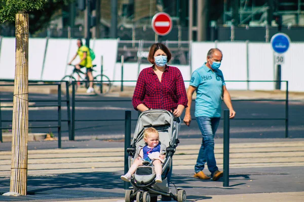 Fransa 'yı 12 Eylül 2020' de, Fransa 'nın Grand Est bölgesindeki bir şehir olan Reims sokaklarında yürüyen koronavirüsten kendilerini korumak için maske takan kimliği belirsiz yayalara bakıyor.