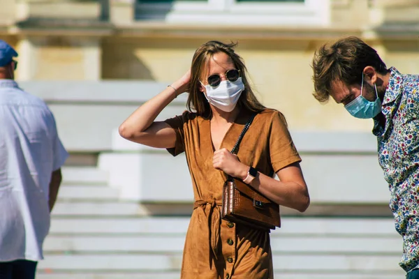 Fransa 'yı 12 Eylül 2020' de, Fransa 'nın Grand Est bölgesindeki bir şehir olan Reims sokaklarında yürüyen koronavirüsten kendilerini korumak için maske takan kimliği belirsiz yayalara bakıyor.