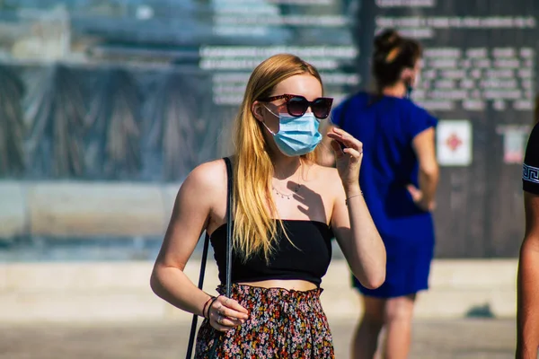 Fransa 'yı 12 Eylül 2020' de, Fransa 'nın Grand Est bölgesindeki bir şehir olan Reims sokaklarında yürüyen koronavirüsten kendilerini korumak için maske takan kimliği belirsiz yayalara bakıyor.