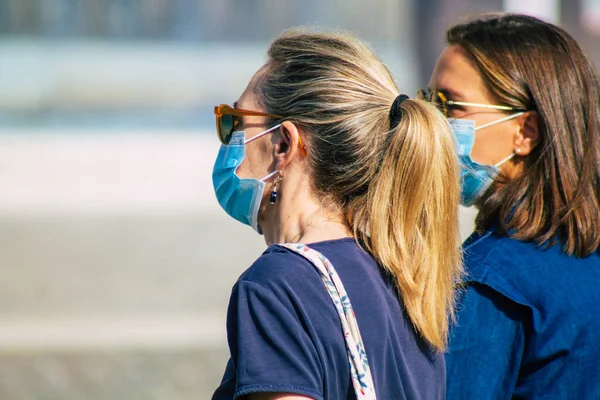 Fransa 'yı 12 Eylül 2020' de, Fransa 'nın Grand Est bölgesindeki bir şehir olan Reims sokaklarında yürüyen koronavirüsten kendilerini korumak için maske takan kimliği belirsiz yayalara bakıyor.