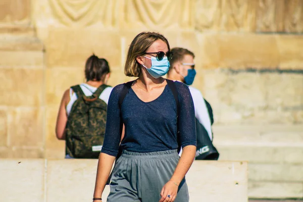 Fransa 'yı 12 Eylül 2020' de, Fransa 'nın Grand Est bölgesindeki bir şehir olan Reims sokaklarında yürüyen koronavirüsten kendilerini korumak için maske takan kimliği belirsiz yayalara bakıyor.