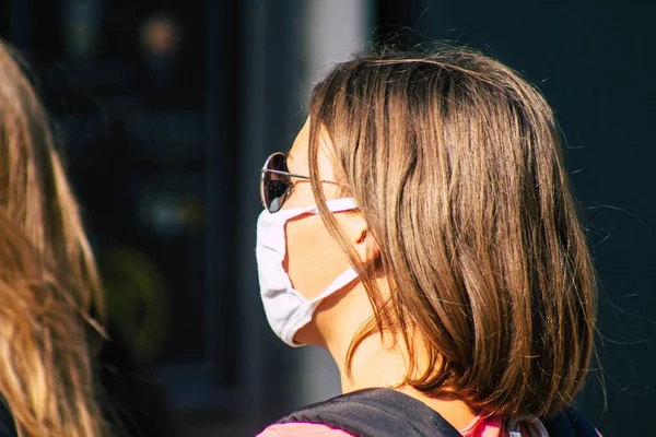 Fransa 'yı 12 Eylül 2020' de, Fransa 'nın Grand Est bölgesindeki bir şehir olan Reims sokaklarında yürüyen koronavirüsten kendilerini korumak için maske takan kimliği belirsiz yayalara bakıyor.