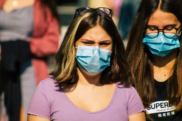 Fransa 'yı 12 Eylül 2020' de, Fransa 'nın Grand Est bölgesindeki bir şehir olan Reims sokaklarında yürüyen koronavirüsten kendilerini korumak için maske takan kimliği belirsiz yayalara bakıyor.