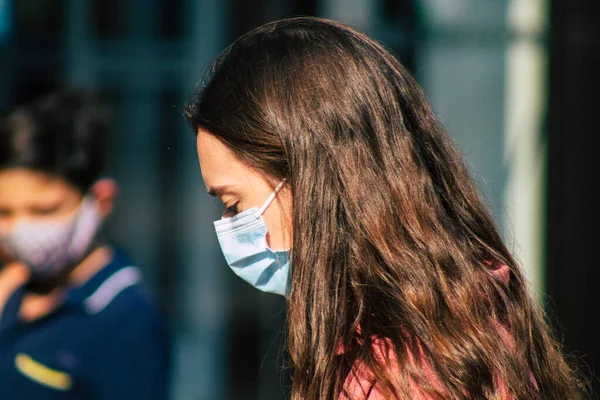 Fransa 'yı 12 Eylül 2020' de, Fransa 'nın Grand Est bölgesindeki bir şehir olan Reims sokaklarında yürüyen koronavirüsten kendilerini korumak için maske takan kimliği belirsiz yayalara bakıyor.